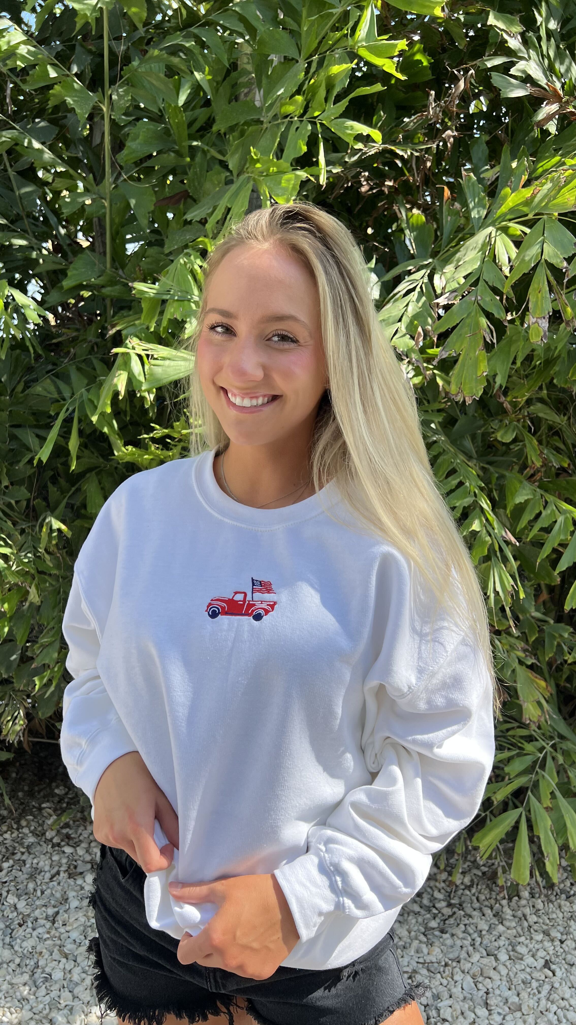 White crewneck with embroidered red truck and American flag